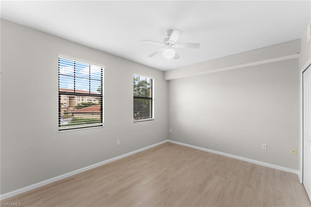 12920 Positano Circle, Unit 303 Naples, FL 34105 - Photo 9 of 21 an empty room with windows and fan