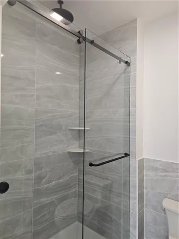 a bathroom with a toilet and a shower