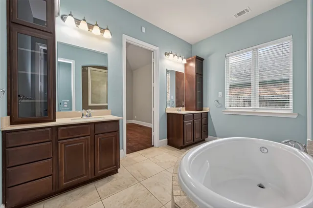 a spacious bathroom with a bathtub and a sink
