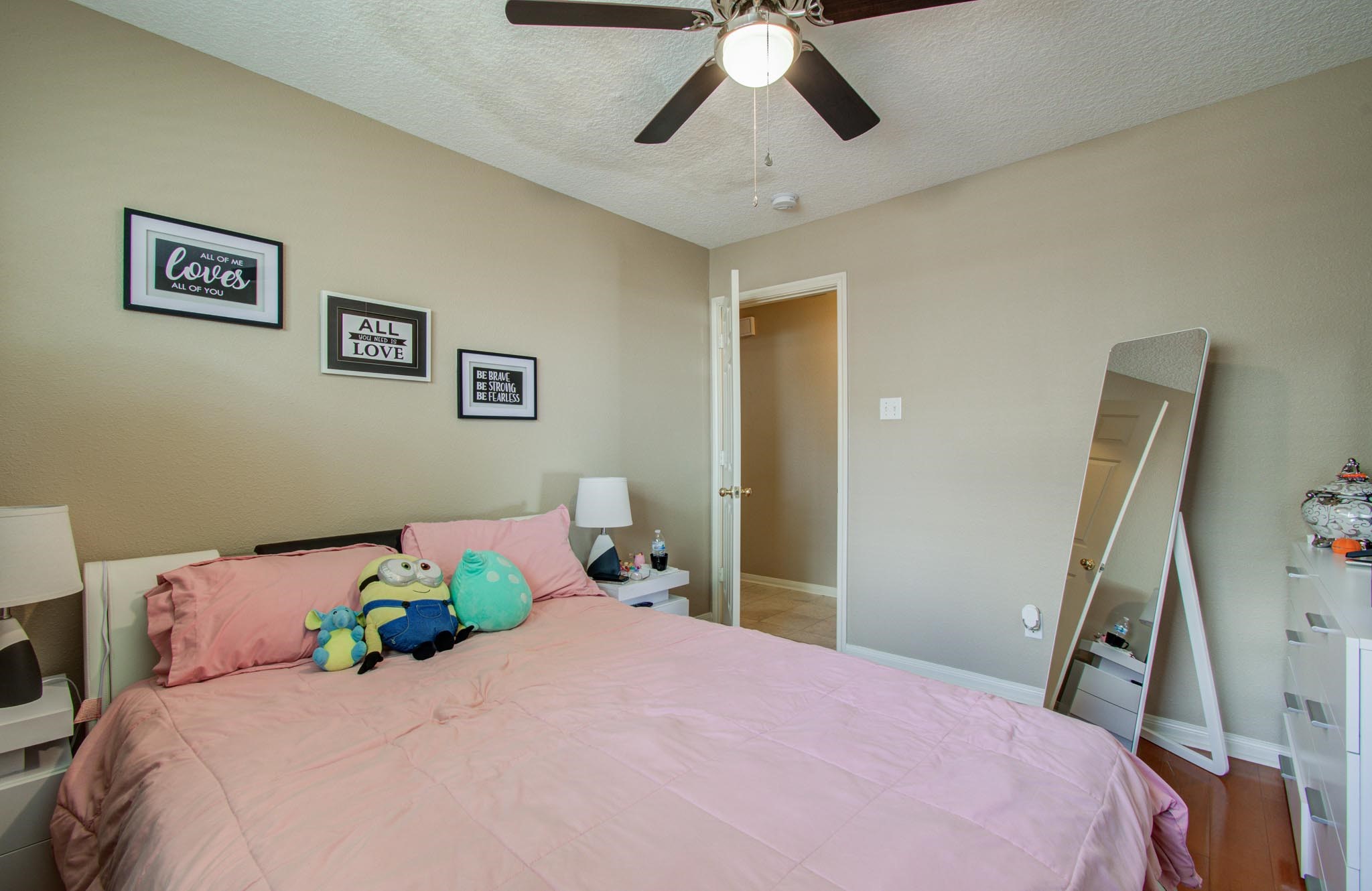 21074 Southern Colony Court Katy, TX 77449 - Photo 22 of 27 a bedroom with a bed and a chandelier