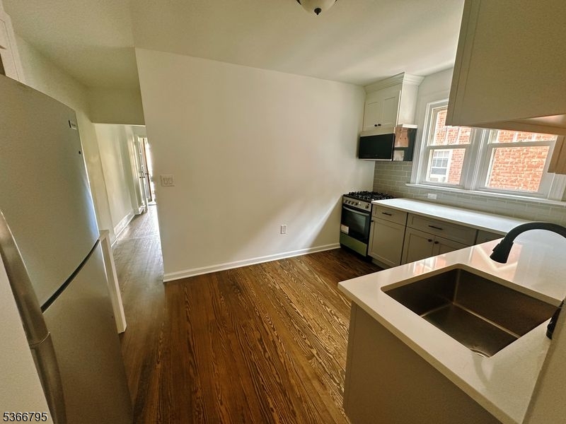 42 Center Street, Unit A Chatham, NJ 07928 - Photo 12 of 16 a view of a kitchen with wooden floor and electronic appliances
