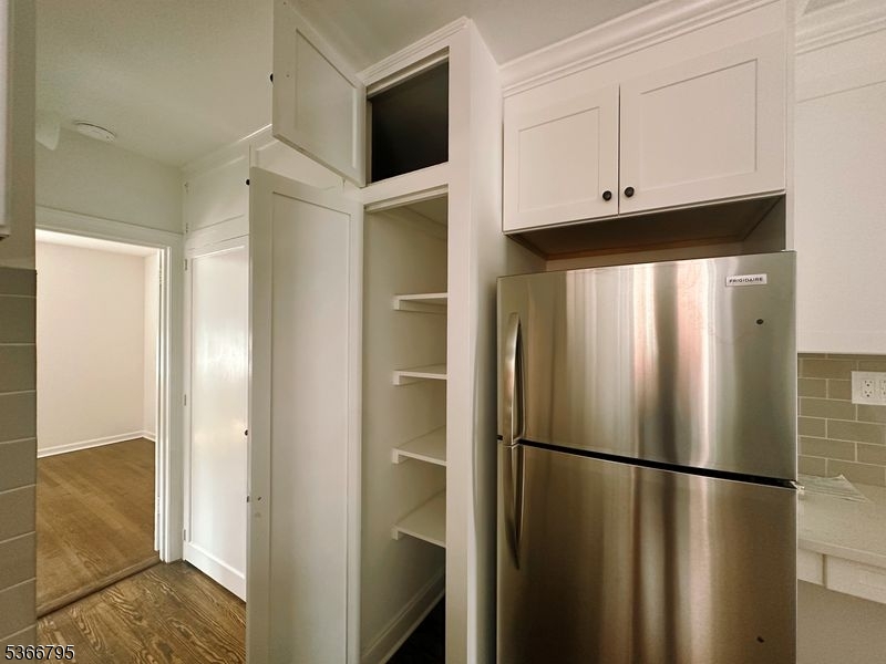 42 Center Street, Unit A Chatham, NJ 07928 - Photo 13 of 16 a view of a refrigerator in kitchen and cabinets