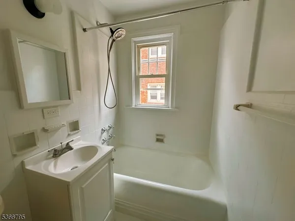 a bathroom with a sink vanity tub and shower