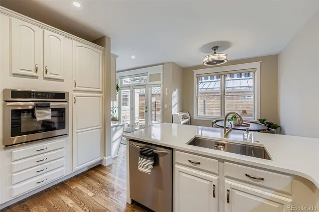a kitchen with granite countertop a sink a counter space appliances and cabinets