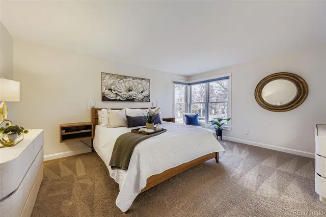 a large bed sitting in a bedroom next to a window with a bookshelf