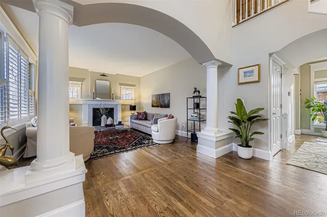 a living room with furniture a fireplace and potted plants