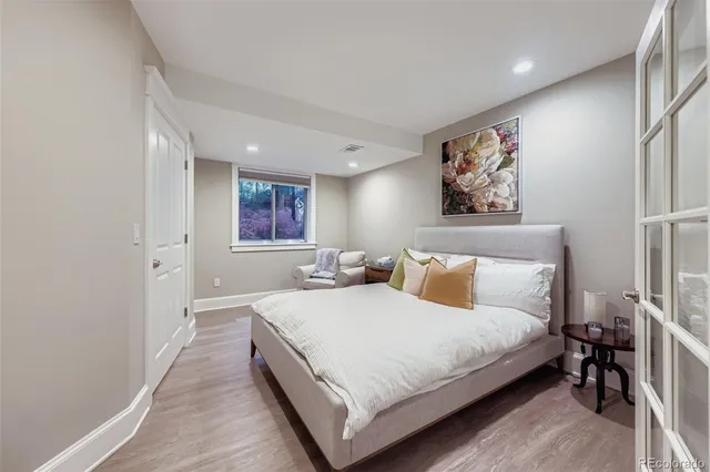 a bedroom with a bed and painting on the wall