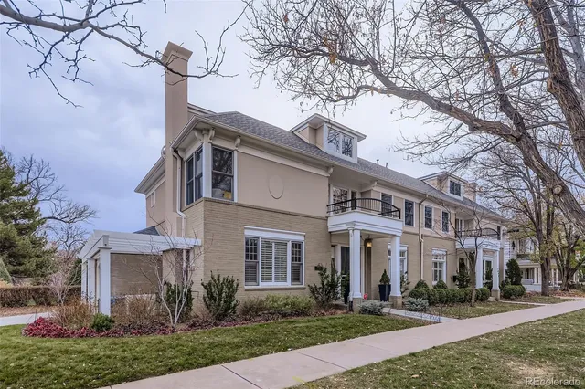 a front view of a building with a garden and plants