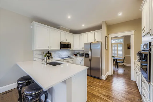 a kitchen with refrigerator cabinets and wooden floor