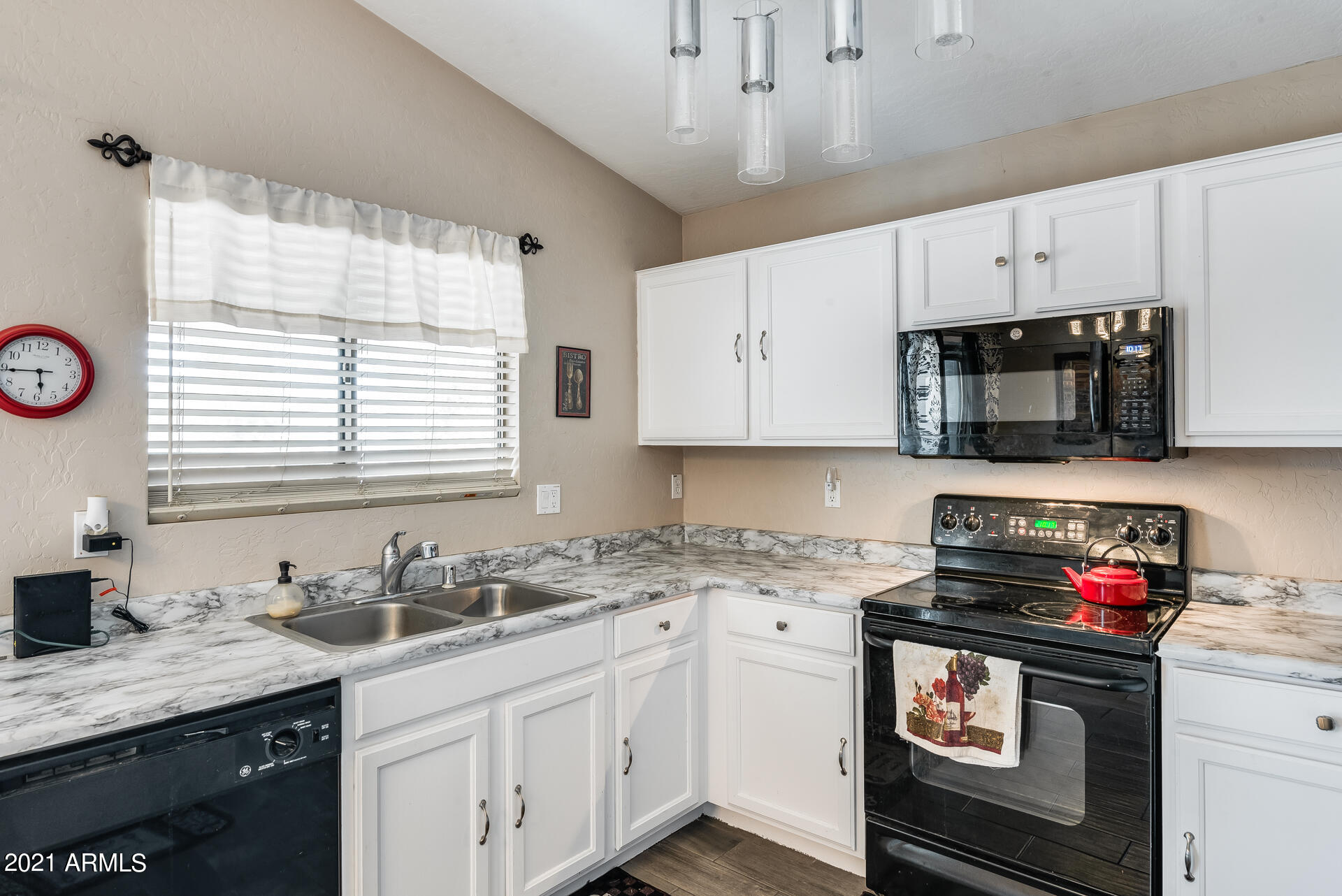 15037 West Calavar Road Surprise, AZ 85379 - Photo 16 of 28 a kitchen with stainless steel appliances a stove a sink a stove and a microwave