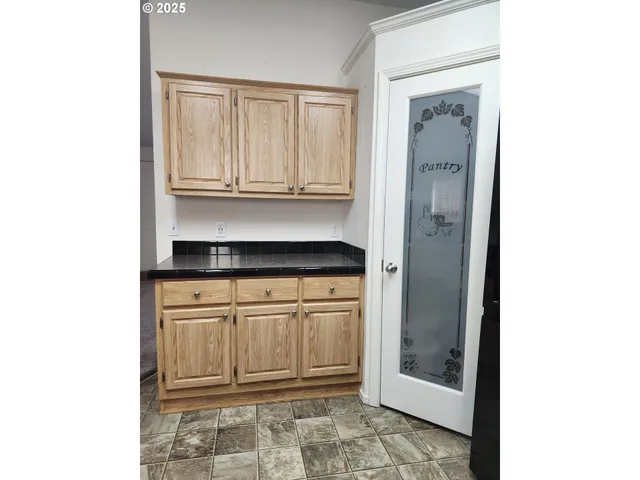 a kitchen with granite countertop a refrigerator and cabinets
