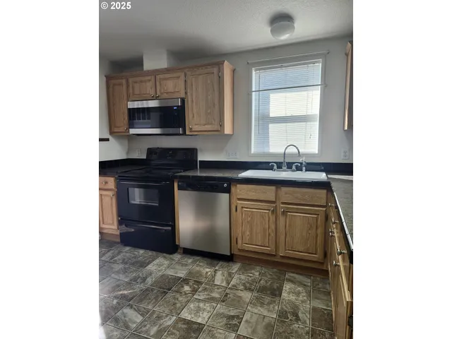 a kitchen with stainless steel appliances granite countertop a sink stove and microwave
