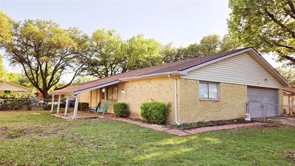 a view of a yard in front of a house with large tree