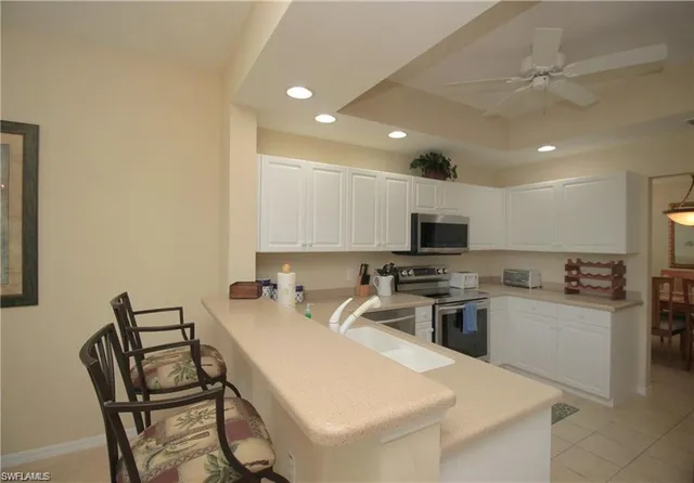 a kitchen with a table chairs microwave and cabinets