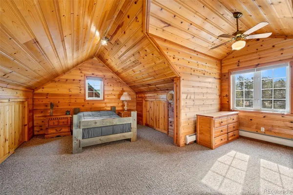 a bedroom with a bed dresser and a large window