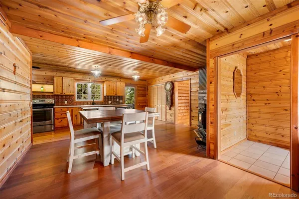 a view of a patio with table and chairs with wooden floor and fence
