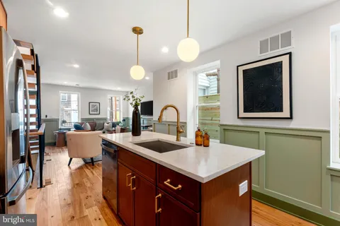 a kitchen with a sink cabinets and wooden floor