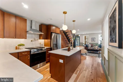 a kitchen with stainless steel appliances granite countertop a stove a sink dishwasher and a refrigerator with wooden floor