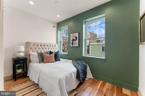 a bedroom with a bed and painting on the wall