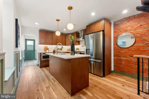 a kitchen with stainless steel appliances granite countertop a refrigerator a oven and a sink