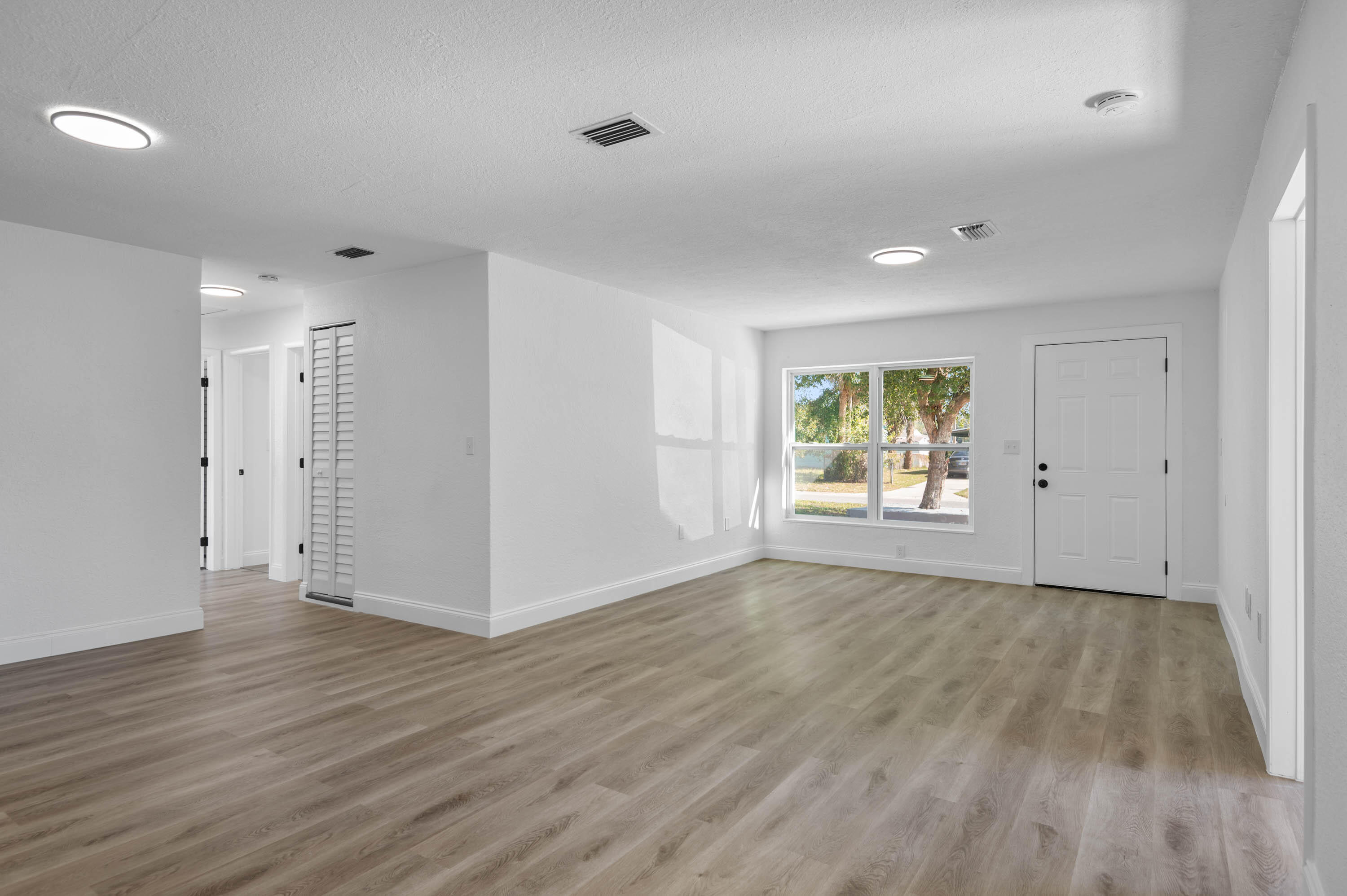 515 A Lane Cocoa, FL 32926 - Photo 11 of 31 a view of an empty room with wooden floor and a window