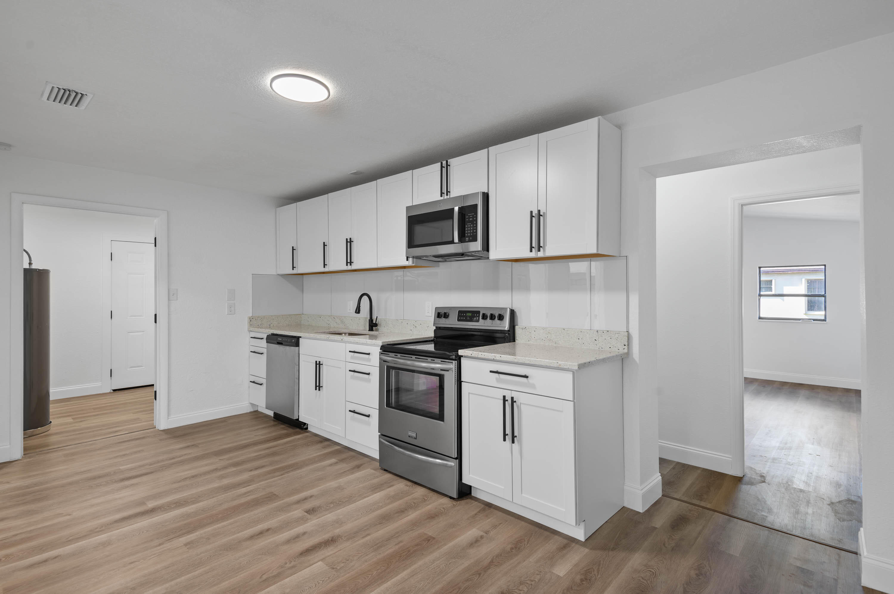 515 A Lane Cocoa, FL 32926 - Photo 12 of 31 a kitchen with cabinets stainless steel appliances and wooden floor