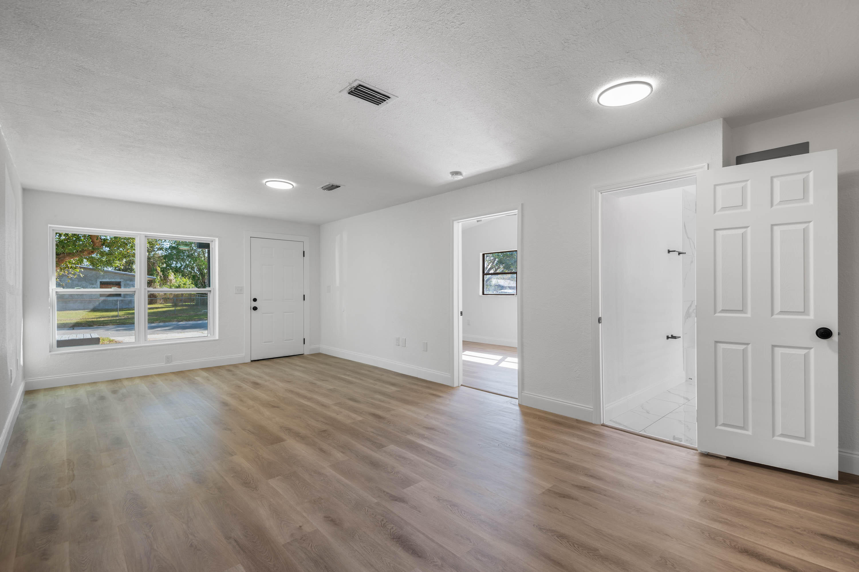 515 A Lane Cocoa, FL 32926 - Photo 14 of 31 an empty room with wooden floor and windows