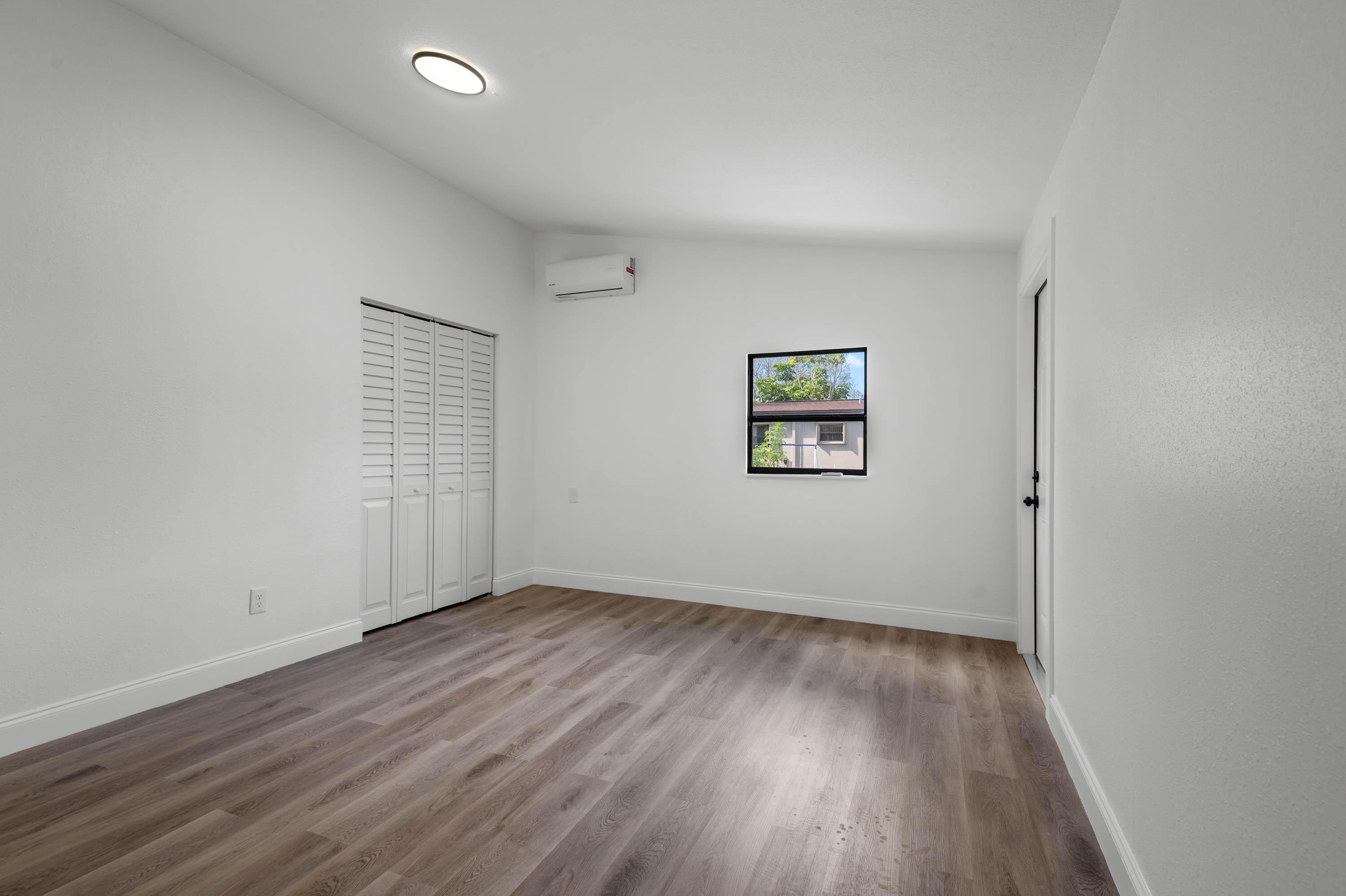 515 A Lane Cocoa, FL 32926 - Photo 21 of 31 an empty room with wooden floor and windows