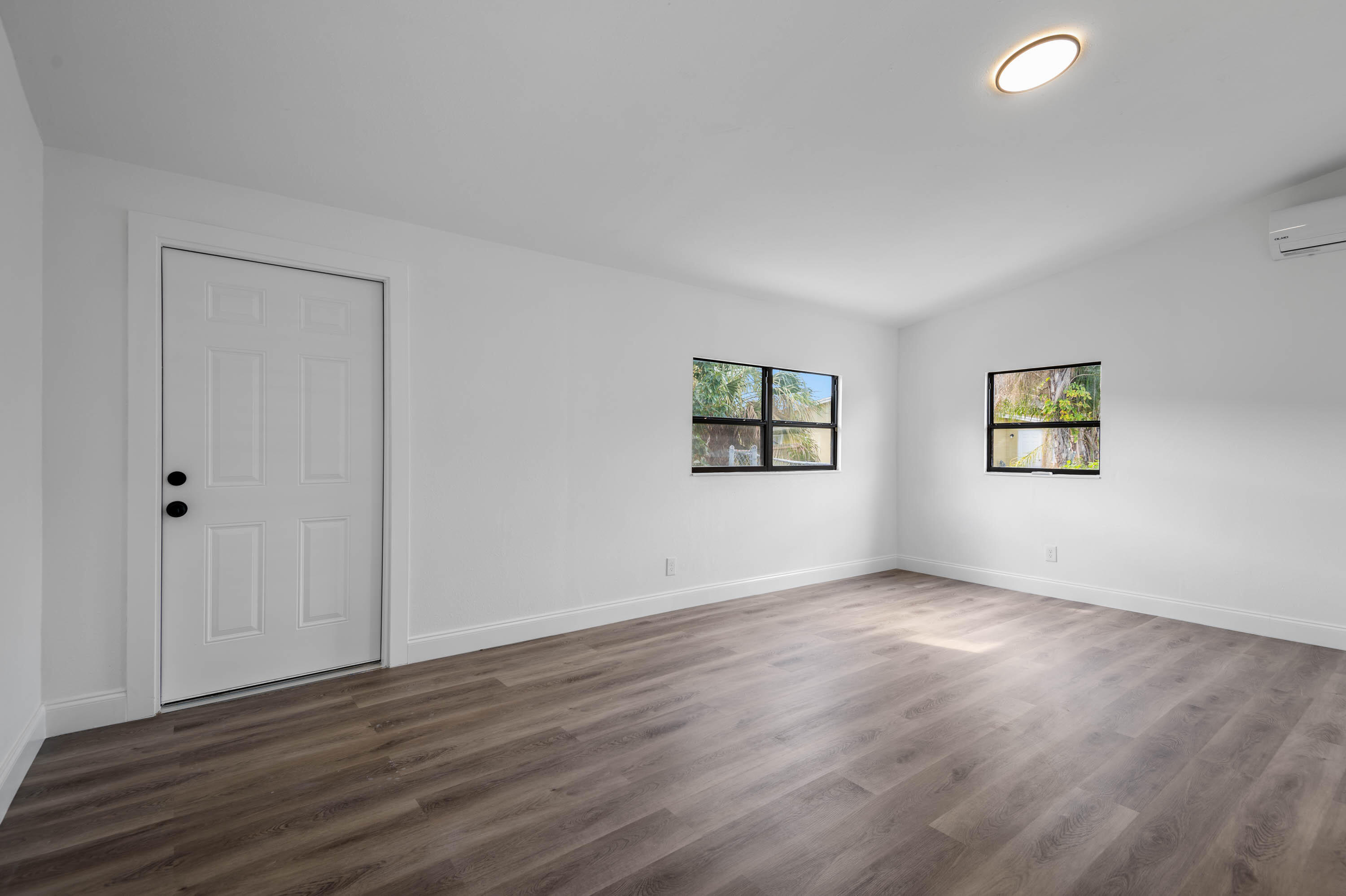 515 A Lane Cocoa, FL 32926 - Photo 23 of 31 a view of an empty room with wooden floor and a window