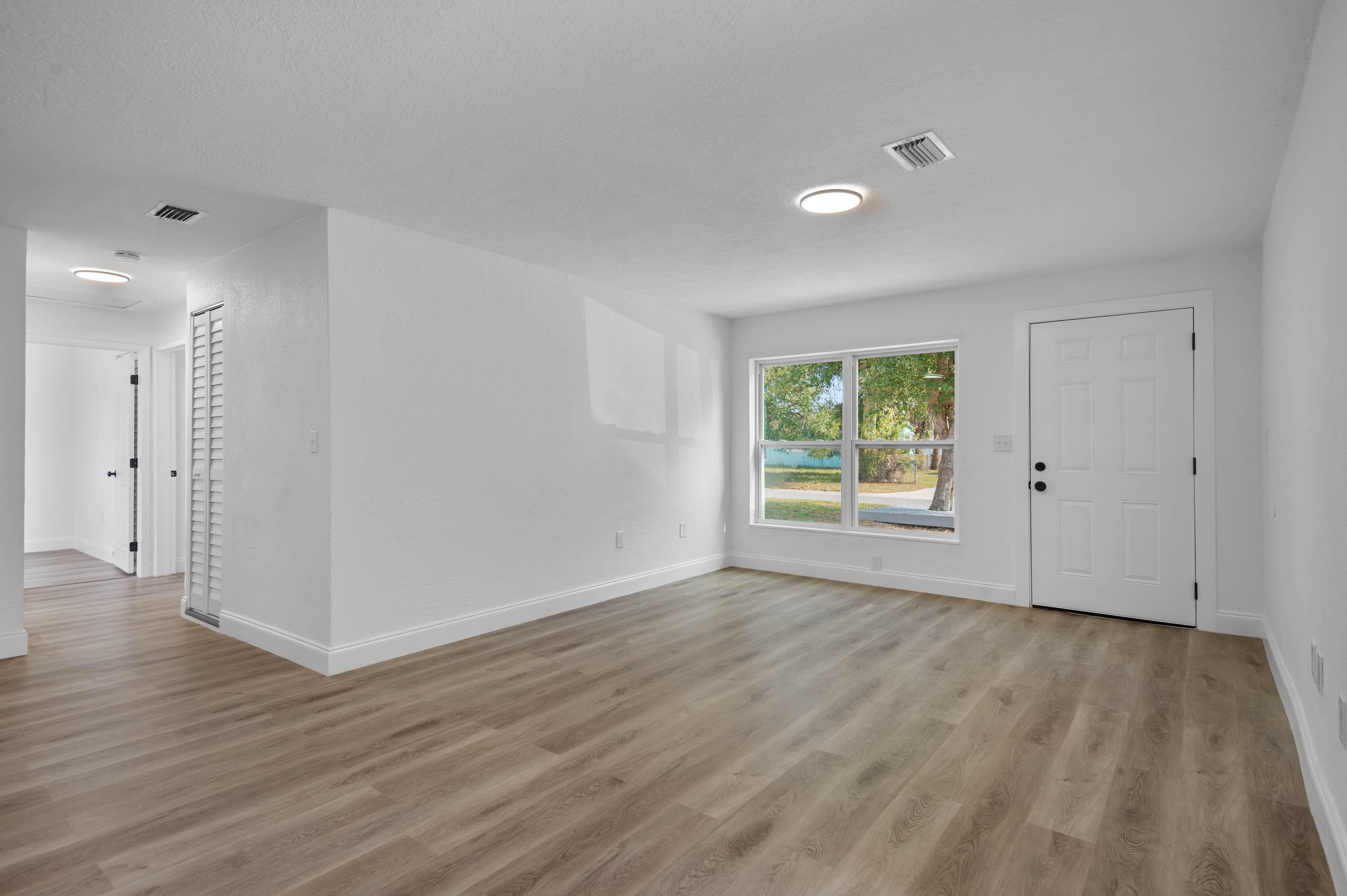 515 A Lane Cocoa, FL 32926 - Photo 5 of 31 a view of an empty room with wooden floor and a window