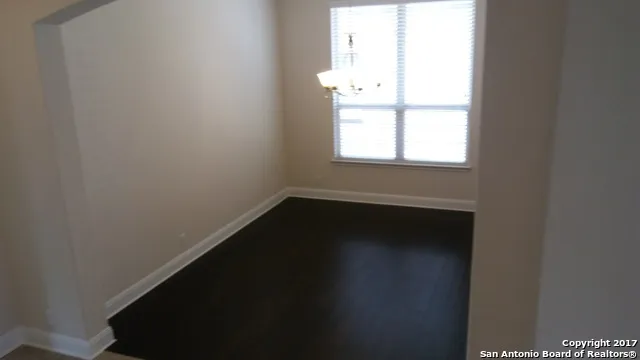 a view of a small space with wooden floor and a window