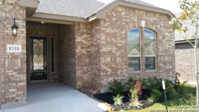 a view of a brick house with potted plants