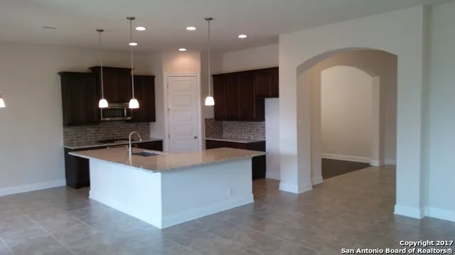 a view of a kitchen with a sink and dishwasher a refrigerator with a fireplace