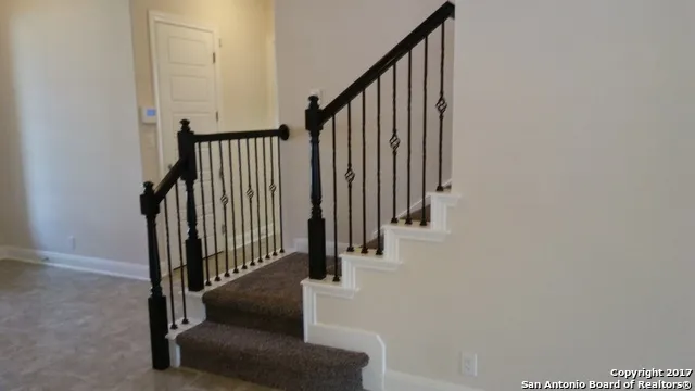 a view of staircase with railing and white walls