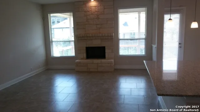 a view of a livingroom with wooden floor and a fireplace