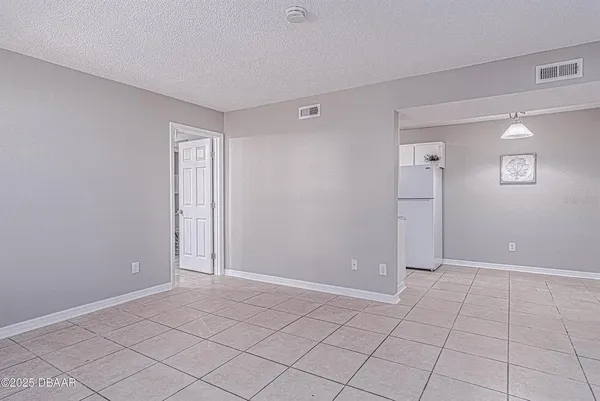 an empty room with kitchen view