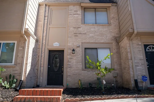 a front view of a house with potted plants