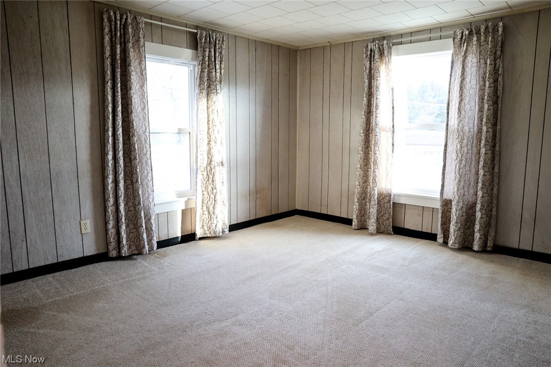 1309 Krumroy Road Akron, OH 44306 - Photo 17 of 30 Carpeted spare room featuring wood walls