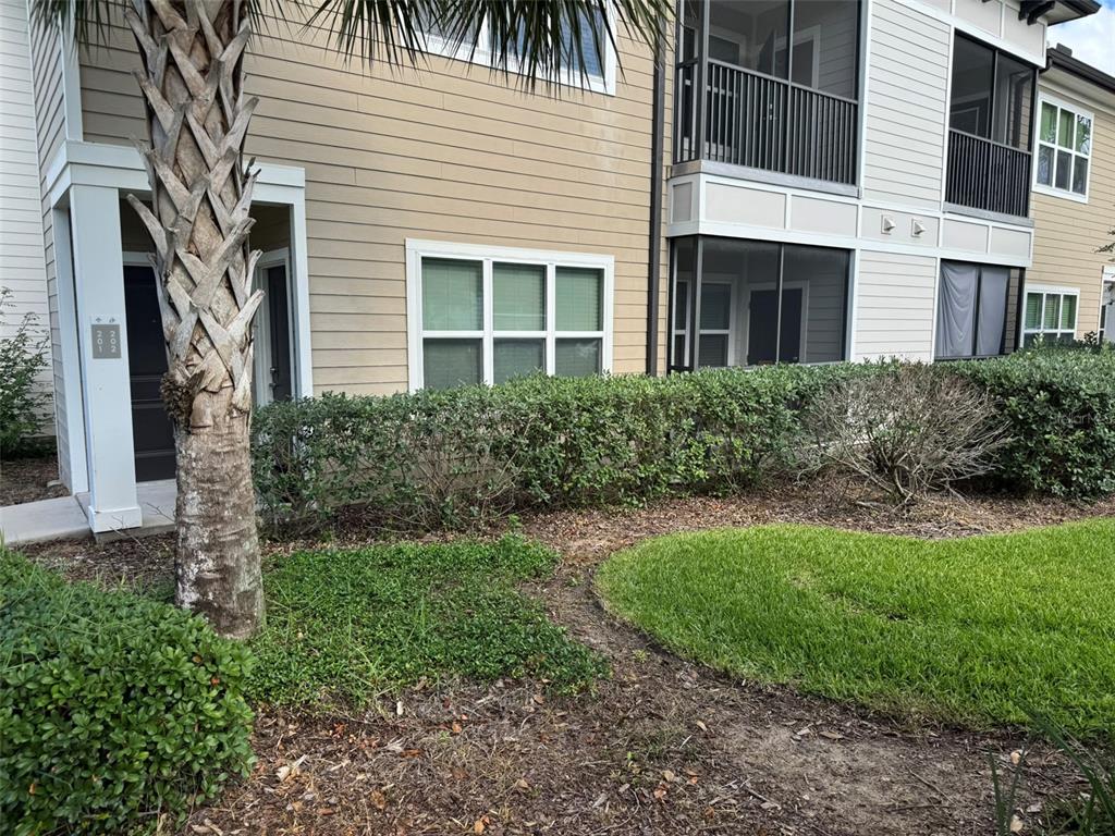 a view of a house with brick walls and a yard with plants