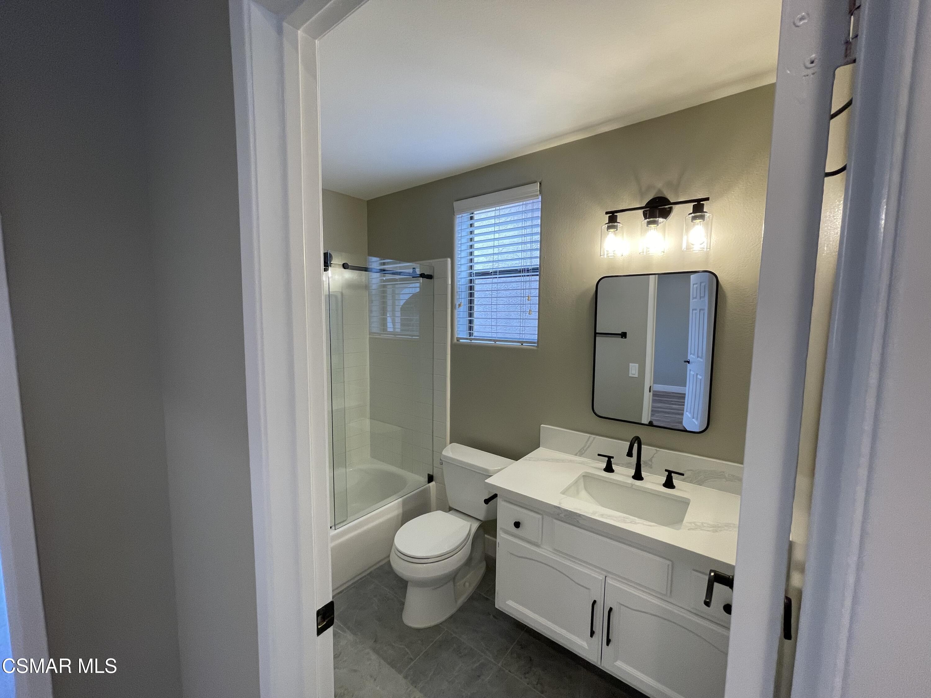 429 Dante Way Oak Park, CA 91377 - Photo 15 of 18 a bathroom with a toilet sink and mirror