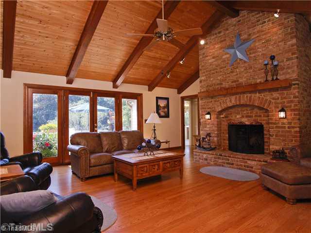 6102 Pintail Court Oak Ridge, NC 27310 - Photo 6 of 16 Den/Family/Great Room. Wall of windows in the Great Room welcomes an abundance of natural light. The soaring cathedral ceiling of pine tongue and groove and floor to ceiling fireplace creates a sense of grandeur.