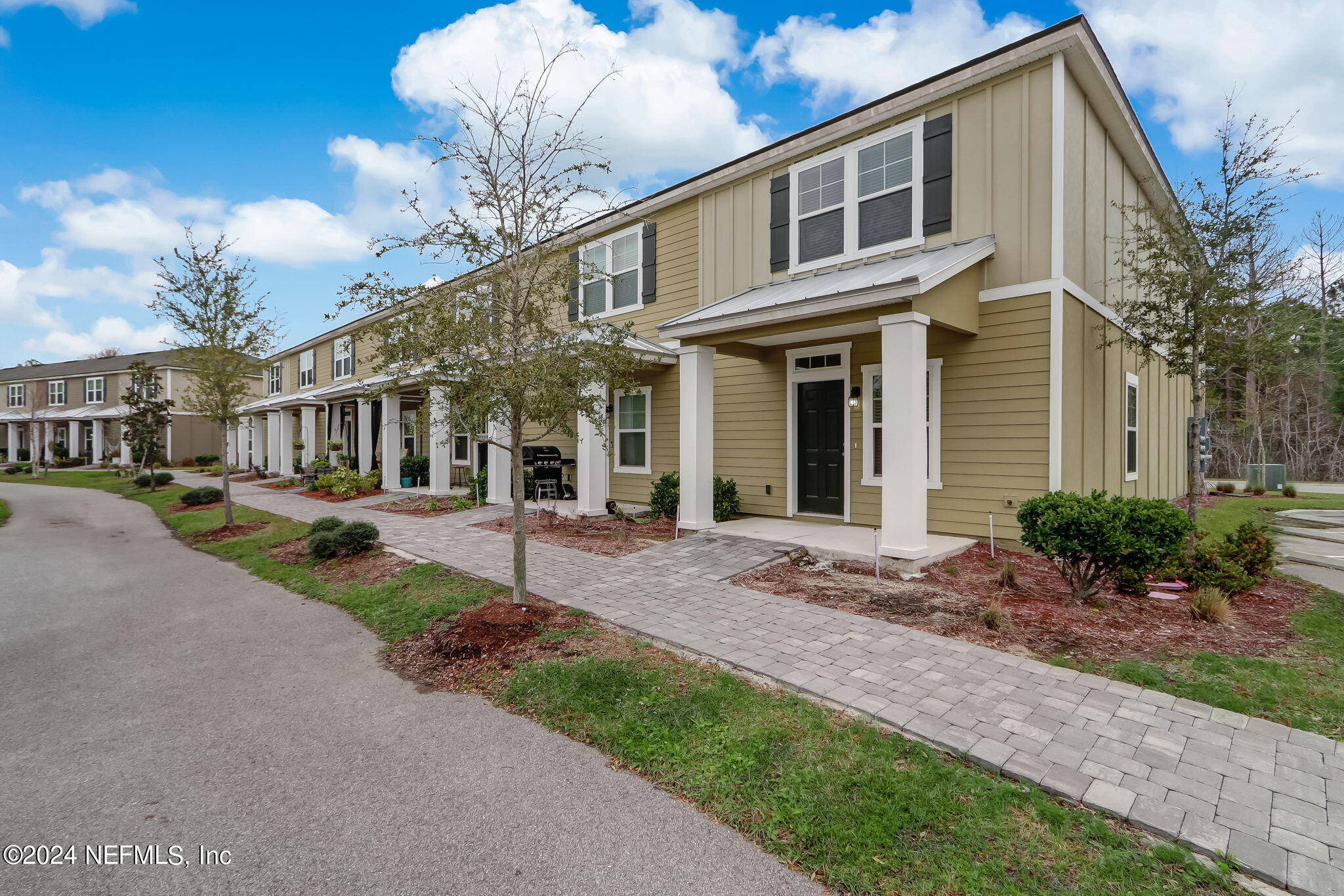 a front view of a house with a garden and plants