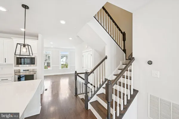 a view of a hallway with wooden floor and staircase