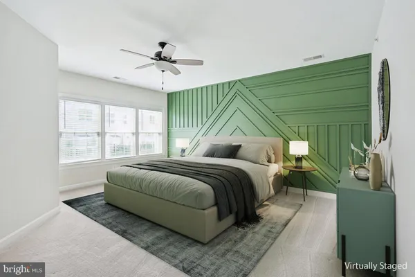 a bedroom with a bed lamp and a large window