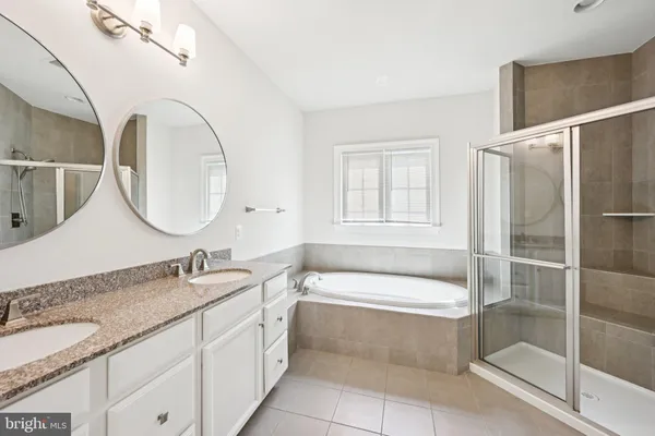 a bathroom with a granite countertop sink mirror and bathtub