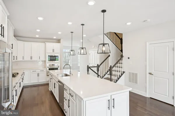 a kitchen with white cabinets sink and white appliances