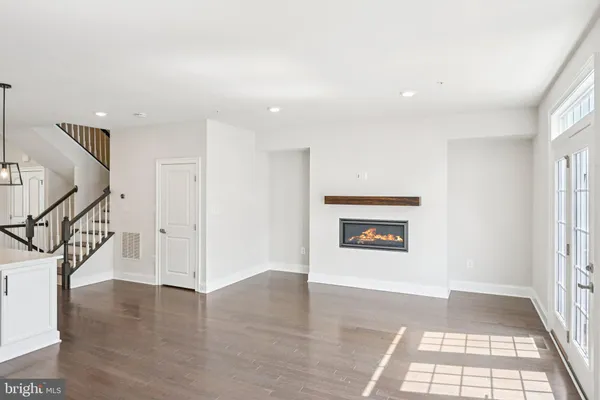 a view of a hallway with wooden floor and windows
