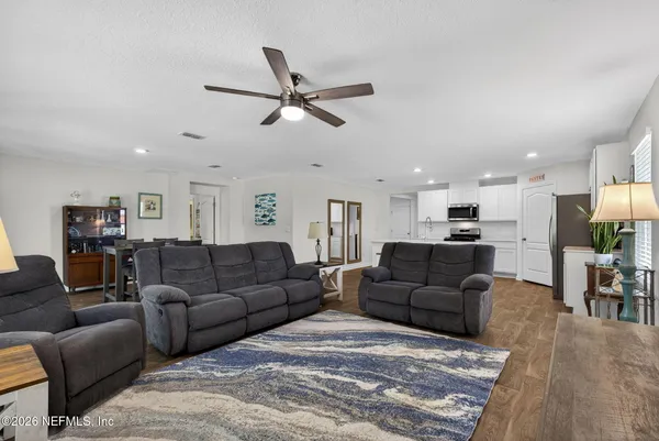 a living room with furniture and a view of kitchen