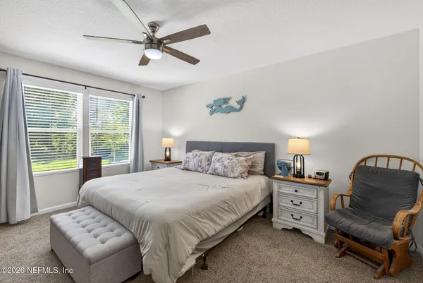 a bedroom with a bed a couch and a window