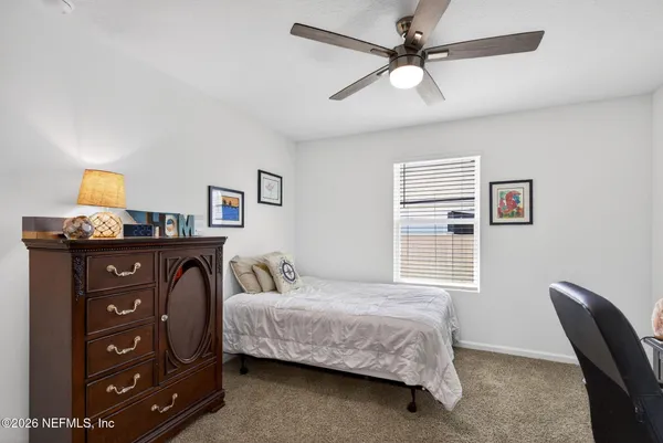 a bedroom with a bed dresser and a window